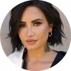 Demi Lovato slightly smiling in headshot on a neutral background