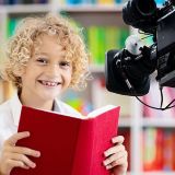 child reading in front of camera