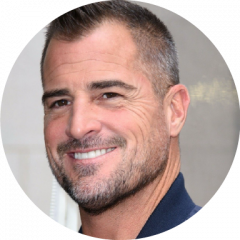 George Eads smiling in profile in a headshot on a white background
