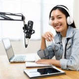teen girl in front of microphone with headphones on