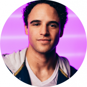 Clinton Greenspan smiling in headshot on pink background