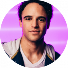 Clinton Greenspan smiling in headshot on pink background